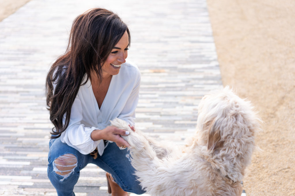 Model in Blue Jeans and white tie front shirt and her dog.