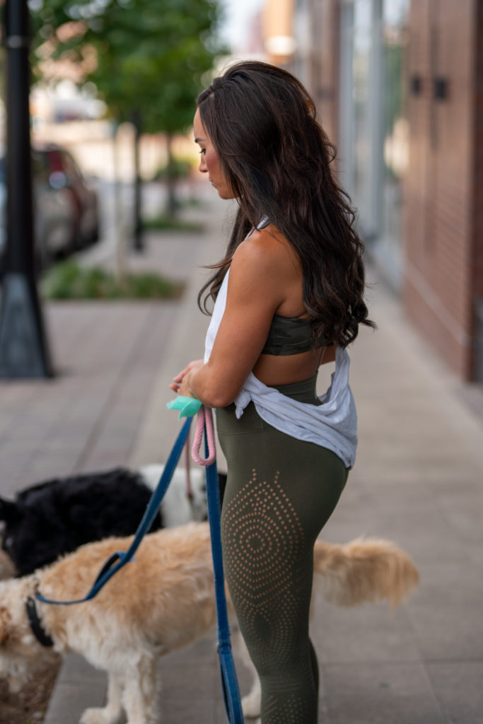 Model wearing leggings walking dog.