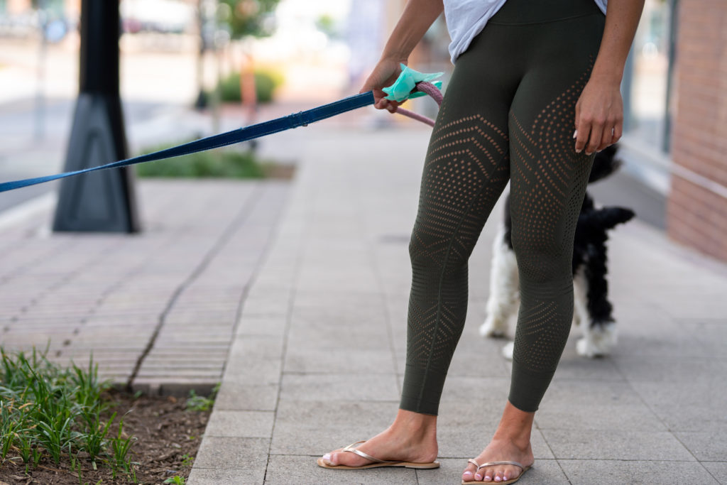 Model wearing leggings walking dog.