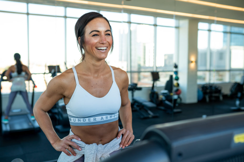 Female on treadmill in the gym wearing sports bra.
